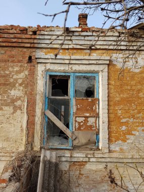 Kırsal kesimdeki kırık camlı ev. Eski püskü boyalarla terk edilmiş bir ev.