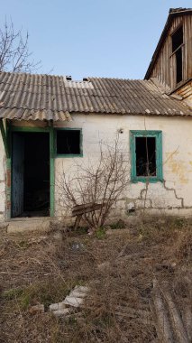 Terk edilmiş kırsal ahır ve kapısı ve penceresi kırık bir ev..