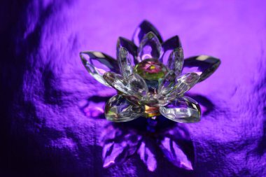 Kristal nilüfer, parlak parlak parlak parlak parlak parlak bir masa üzerinde, ışık yansımalı. Sahasrara çakra sembolü. Esrarengiz, reiki enerjisi, meditasyon, ruhsal iyileştirme.