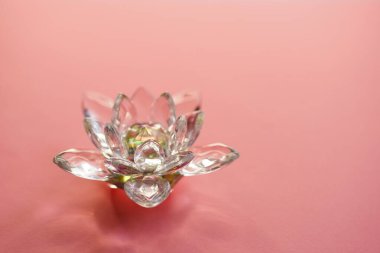 Crystal lotus on pink table. Symbol of purity, rebirth and enlightenment