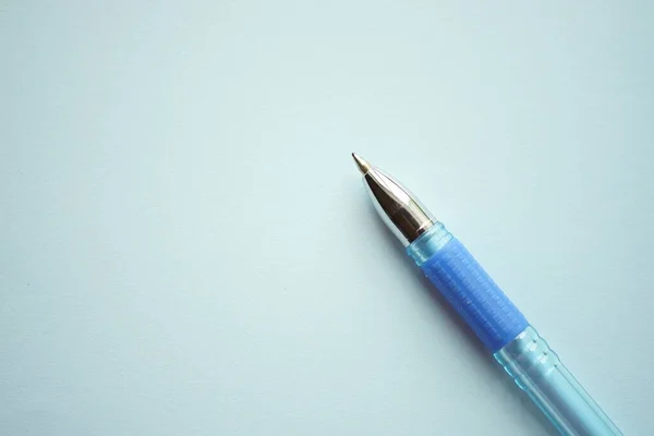 浅蓝色纸上的蓝色圆珠笔 — 图库照片
