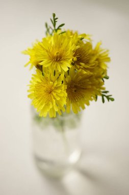 Beyaz masadaki sarı çiçek buketi, sanat kartı.