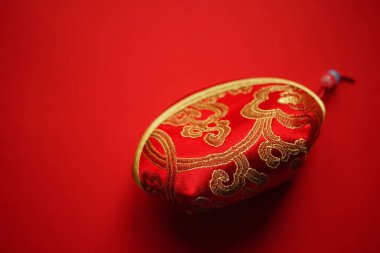 red cosmetic bag with gold embroidery.