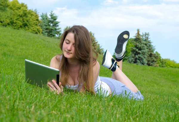 Vrouw ontspannen met een touchscreen tablet — Stockfoto