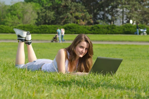 Estudante usando um laptop no parque — Fotografia de Stock