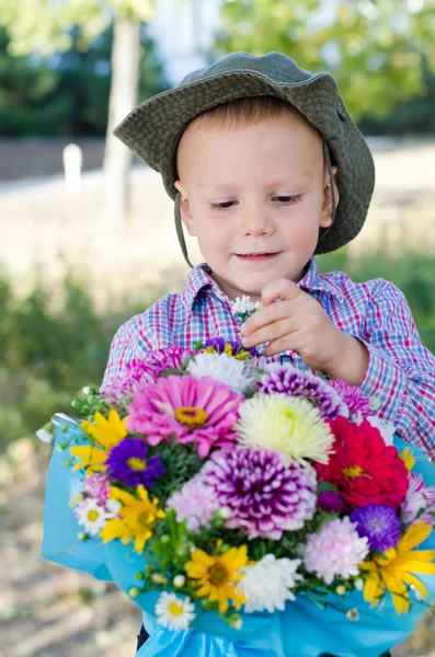 Jongen nemen een enkelvoudige bloem van een boeket — Stockfoto