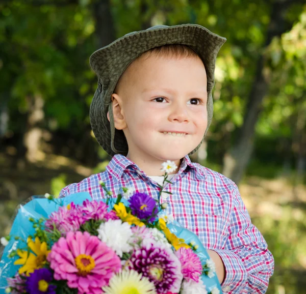 Kleine jongen met bloemen voor zijn geliefde — Stockfoto