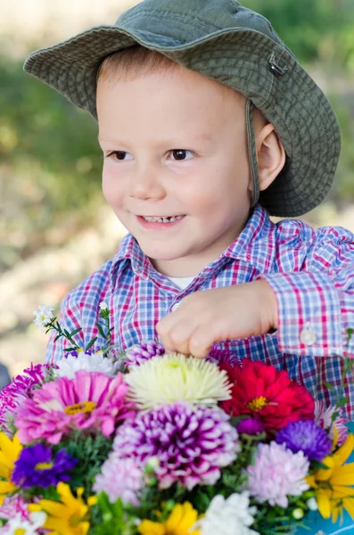 Ondeugend jongetje met bloemen — Stockfoto