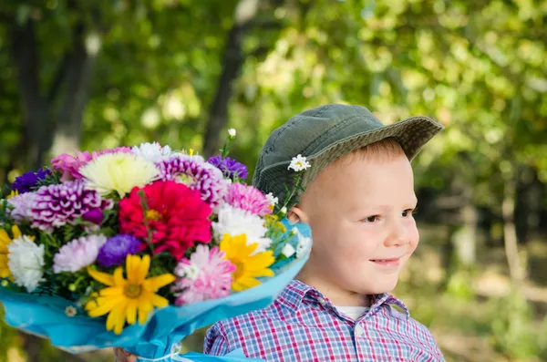 Little boy with flowers for a loved one — Stock Photo, Image