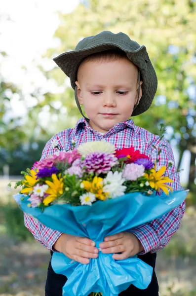 Kleine jongen met bos van bloemen — Stockfoto