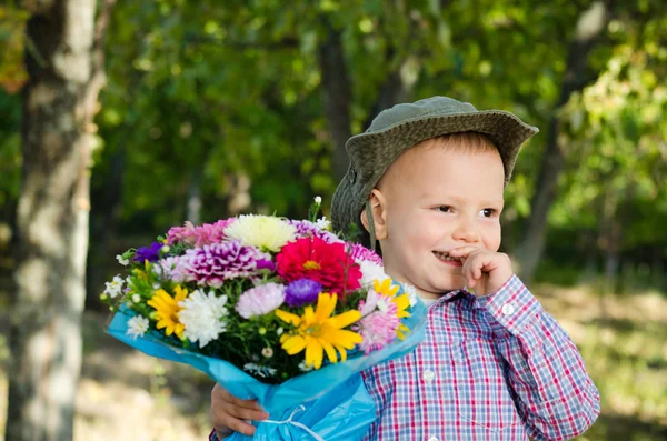 Verlegen jongetje met een boeket van bloemen — Stockfoto