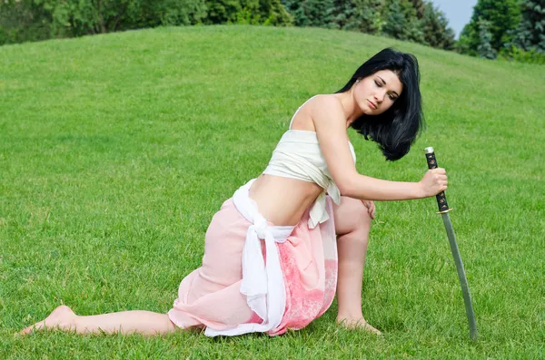 Kvinna poserar med ett svärd — Stockfoto