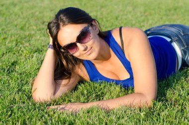 çekici bir kadın yeşil çim üzerinde yalan