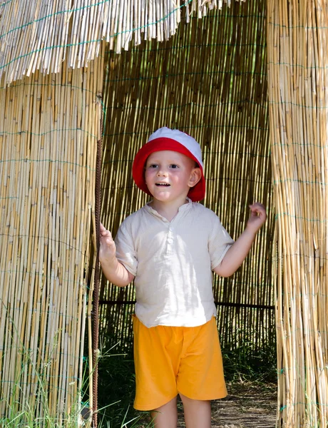 Petit garçon excité dans une cabane de roseaux — Photo