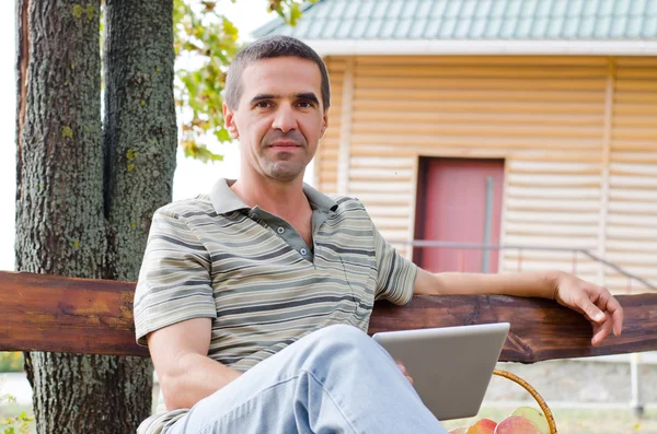 Mann entspannt sich auf Gartenbank — Stockfoto