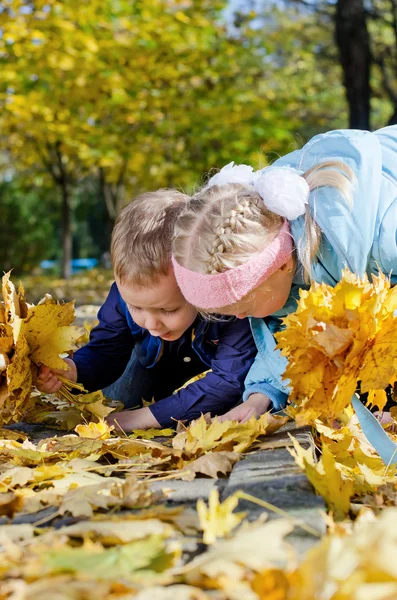 Enfants cherchant parmi les feuilles d'automne — Photo