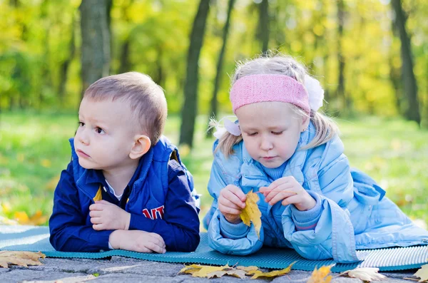 Små barn avkopplande i en park — Stockfoto