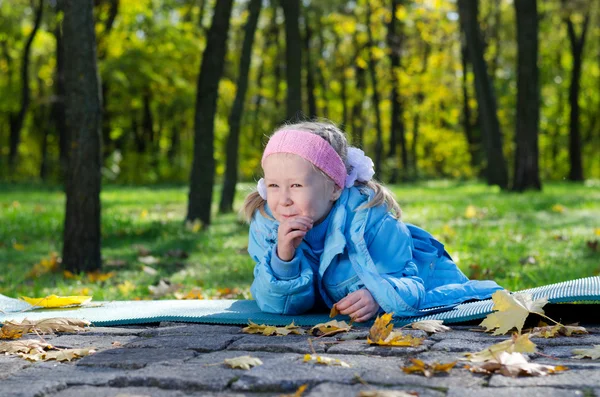 Zlomyslný malá holčička v parku — Stock fotografie