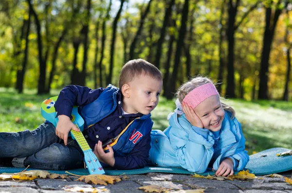 Broer en zus in een park spelen — Stockfoto