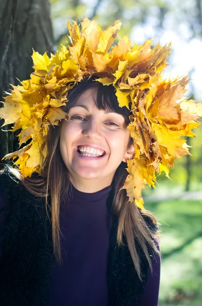 Laughing woman wearing autumn leaves — Stock Photo, Image