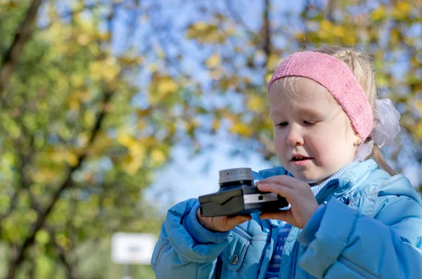 Kleines Mädchen fasziniert von einer alten Kamera — Stockfoto