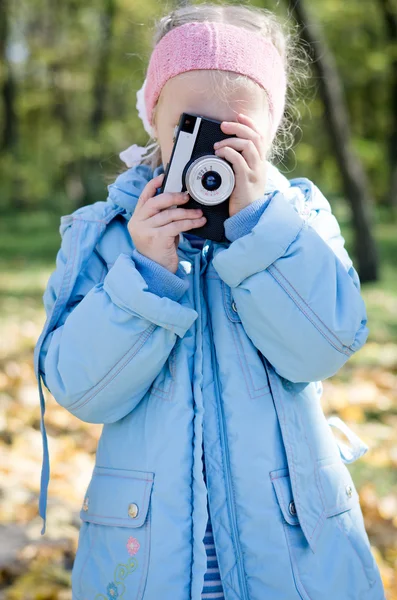 Malá dívka si hraje s slr fotoaparát — Stock fotografie