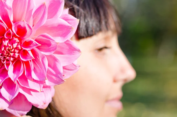 Woman with a dahlia in her hair — Stock Photo, Image