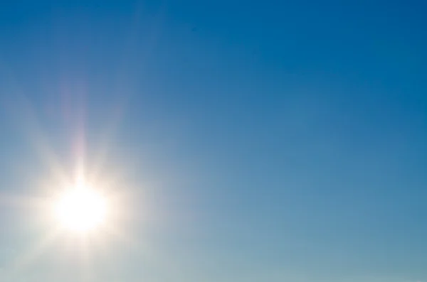 Heldere zon flare in blauwe hemel — Stockfoto