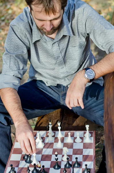 Мужчина средних лет играет в шахматы на природе — стоковое фото