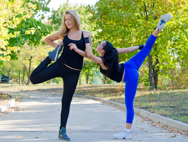 Two young women exercising in a park — Stock Photo, Image