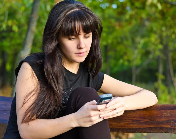 かなり若い女の子彼女の携帯電話にテキストが送れる — ストック写真