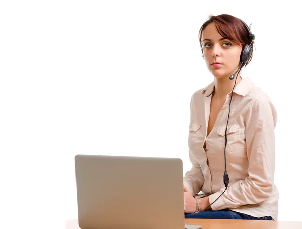 Mujer con auriculares sentada en un escritorio —  Fotos de Stock