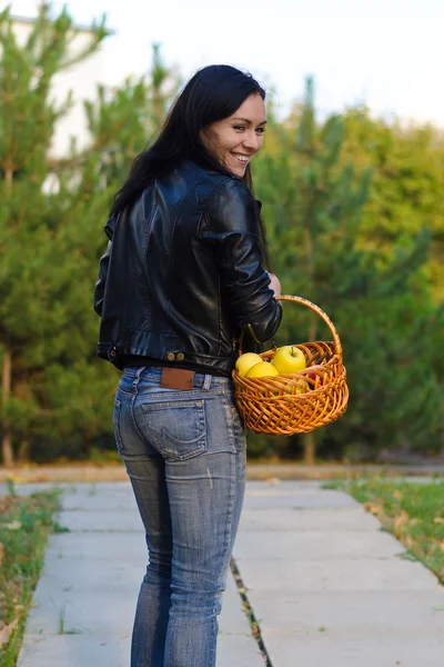 Улыбающаяся женщина с корзиной яблок — стоковое фото