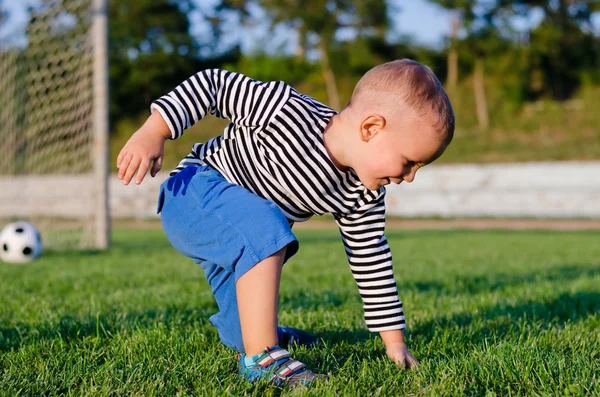 Mignon petit garçon sur un terrain de football — Photo