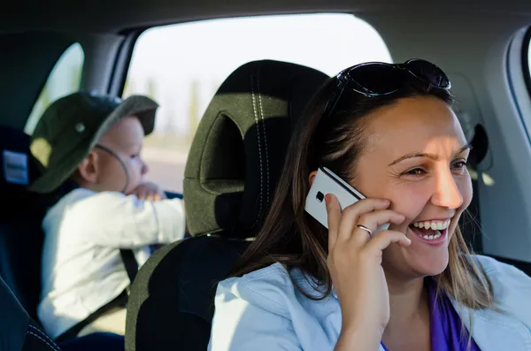 Kvinna driver skrattar på sin mobiltelefon — Stockfoto