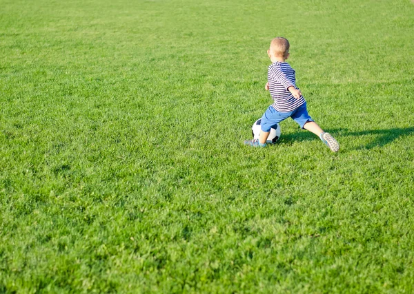 Liten pojke spelar fotboll — Stockfoto