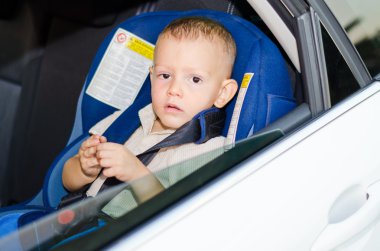 çocuğu sabırla bir arabanın arka koltuğunda oturan çocuk güvenlik koltuğu