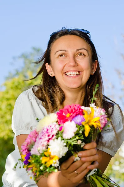 Glad skrattande kvinna med blommor — Stockfoto