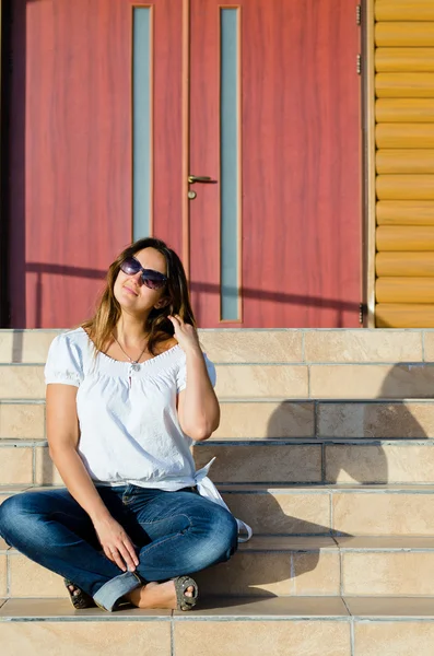Donna felice seduta su gradini — Foto Stock