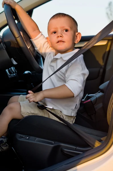 Menino bonito no banco dos motoristas de um carro — Fotografia de Stock