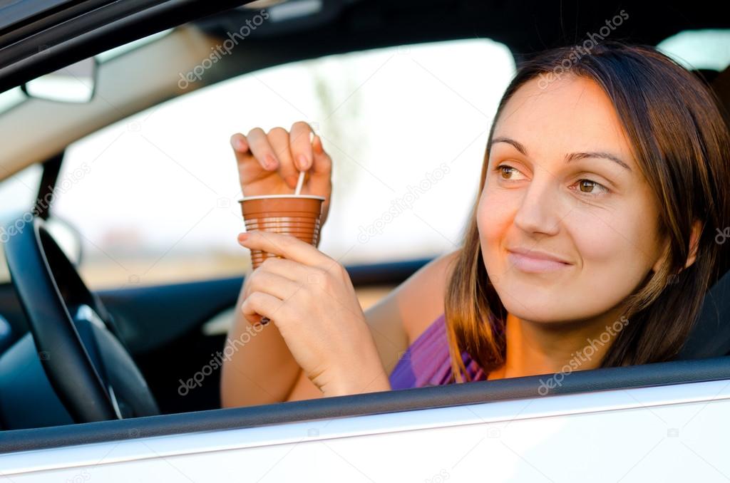 Woman enjoying coffee in her car