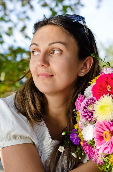 Mujer pensativa con hermosas flores —  Fotos de Stock