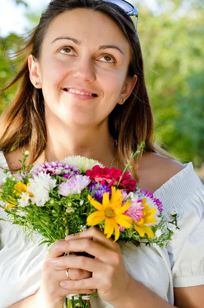 Smiling happy woman holding a floral bouquet — Stock Photo, Image