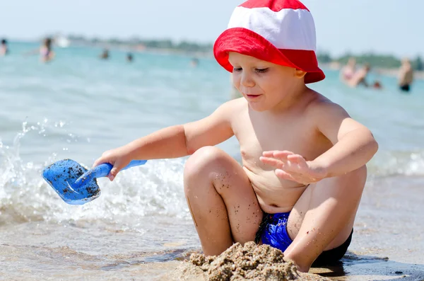 Kleine jongen spelen op de zee — Stockfoto