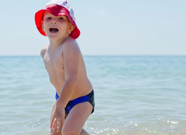 Bonito menino brincando no mar — Fotografia de Stock