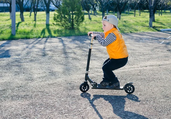 Carino ragazzino cavalcando uno scooter — Foto Stock