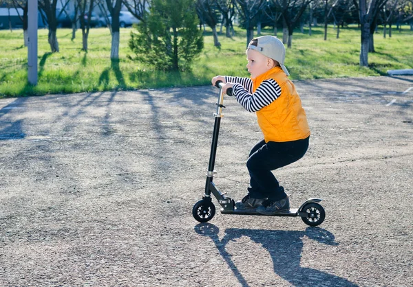 Niedlicher kleiner Junge auf einem Motorroller — Stockfoto