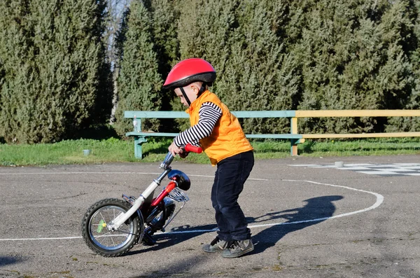 Menino brincando com sua bicicleta ao ar livre — Fotografia de Stock