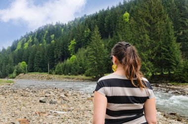 Woman admiring a mountain river