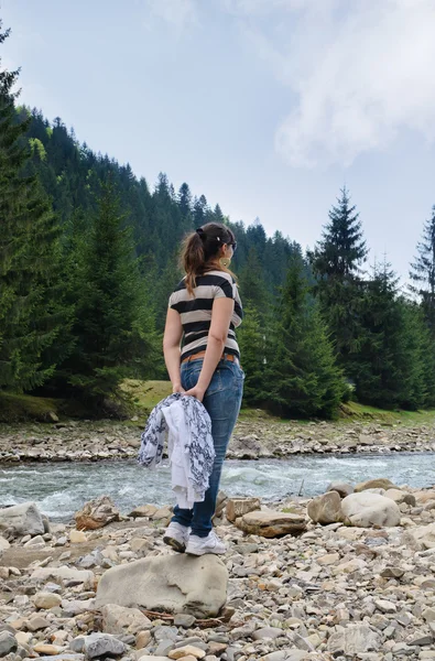 Frau steht und beobachtet einen Fluss — Stockfoto